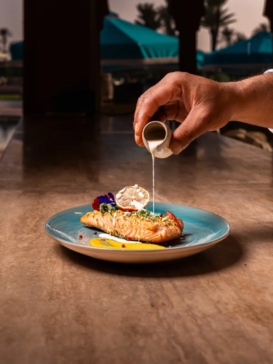 Dressage d'un plat de saumon dans un restaurant au bord de la piscine à Marrakech
